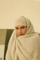 A woman wearing a headscarf is posing for a picture.