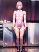 A woman in a pink bodysuit standing in a kitchen.