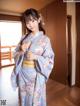 A woman in a blue kimono standing in a room.