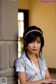 A woman wearing a pink headband leaning against a wall.